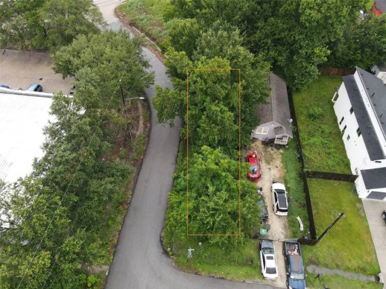 Aerial showing the wooded land offering at 7900 Tower Street with listing-supplied outline