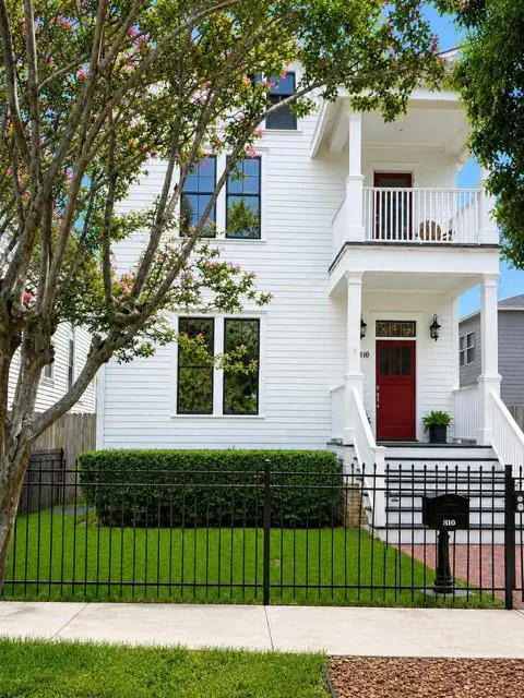 Exterior photograph of 810 Tulane Street in Houston, with white siding and a red front door