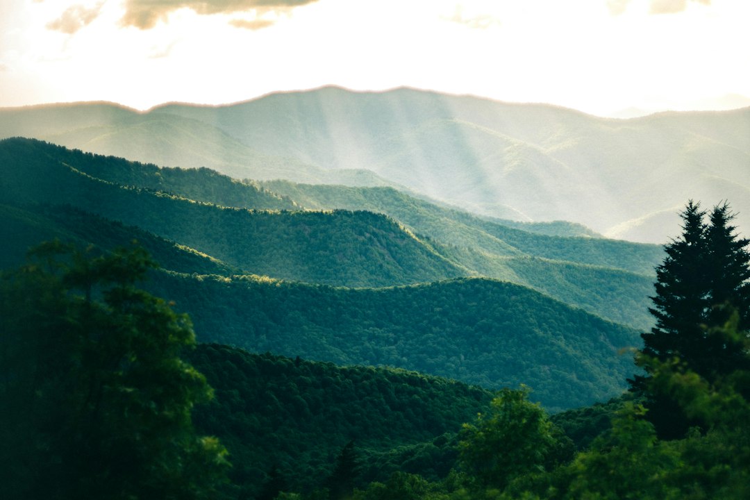the sun shines through the clouds in the mountains